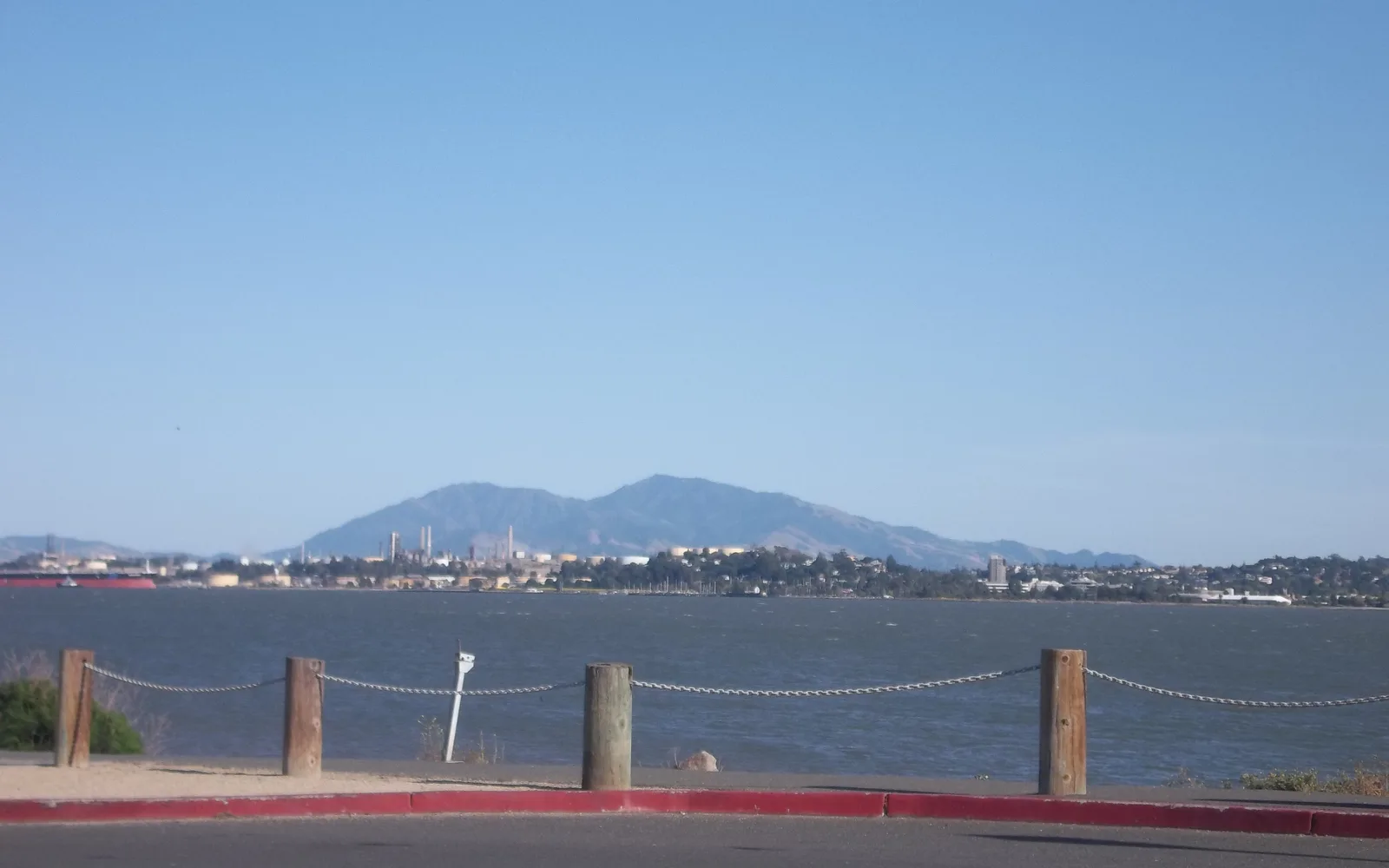 View of Mount Diablo and the Carquinez Strait from Benicia Pier, with industrial facilities visible along the shoreline